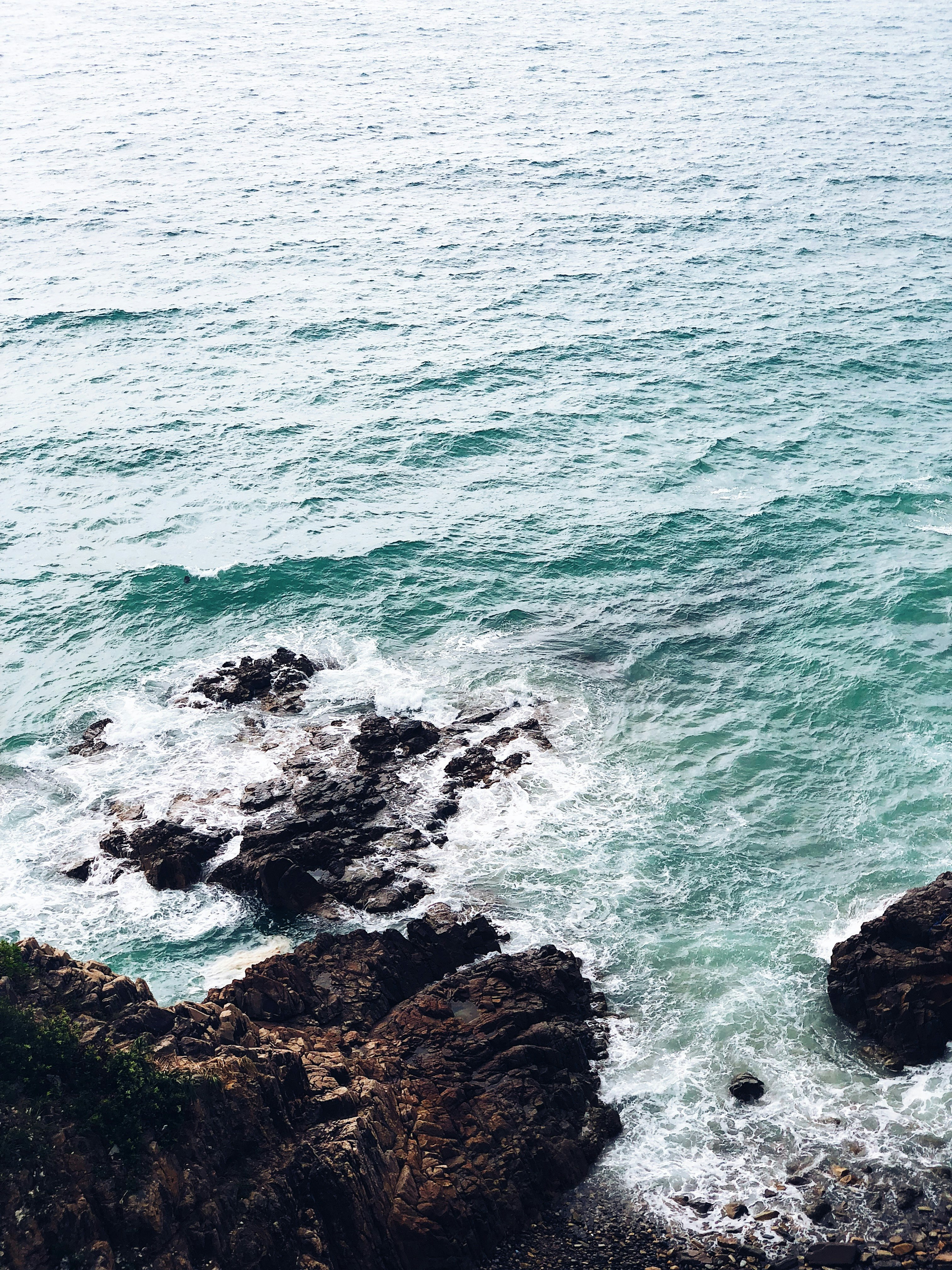 sea water crashing on seashore rocks